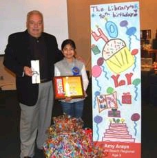 Miami Dade Public Library System Bookmark Contest winner Amy Araya and Library Director Raymond Santiago.