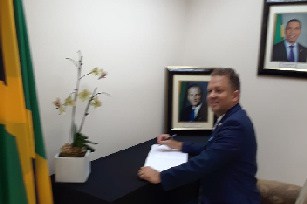 Consul General R. Oliver Mair signing the Condolence Book for former PM Edward Seaga.
