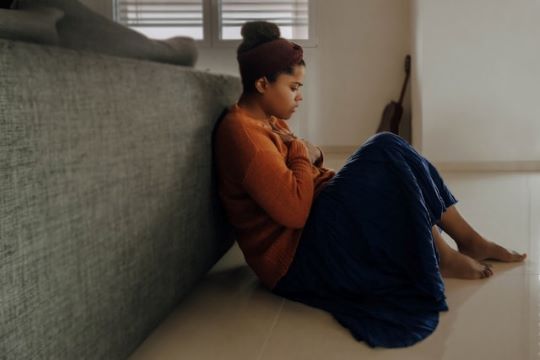 Anxious person sitting on the floor